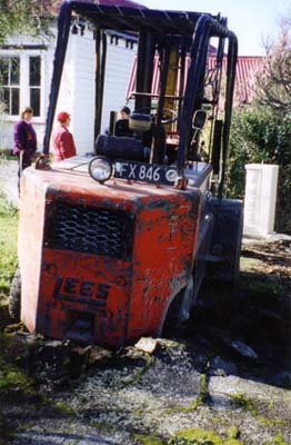 Forklift stuck in broken asphalt beside the sculpture